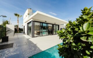 white and grey concrete building near swimming pool under clear sky during daytime